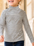 Child wearing a cream and black striped long-sleeve turtleneck top.