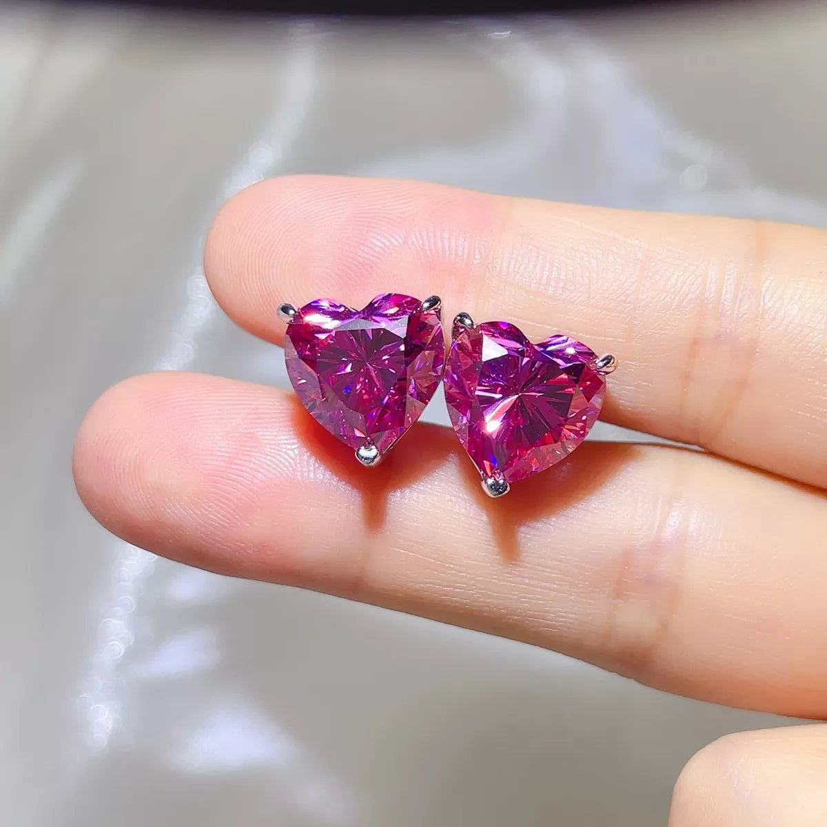 Pink heart-shaped gemstone stud earrings — detail view