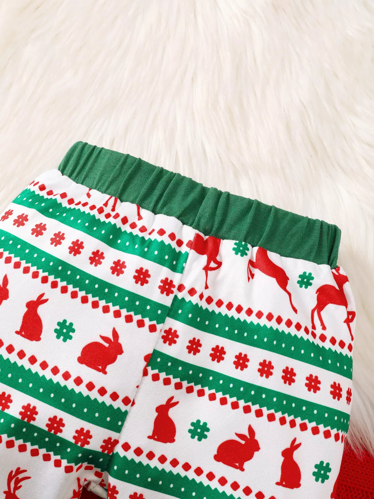 Close-up of the Christmas-patterned pants with green waistband.