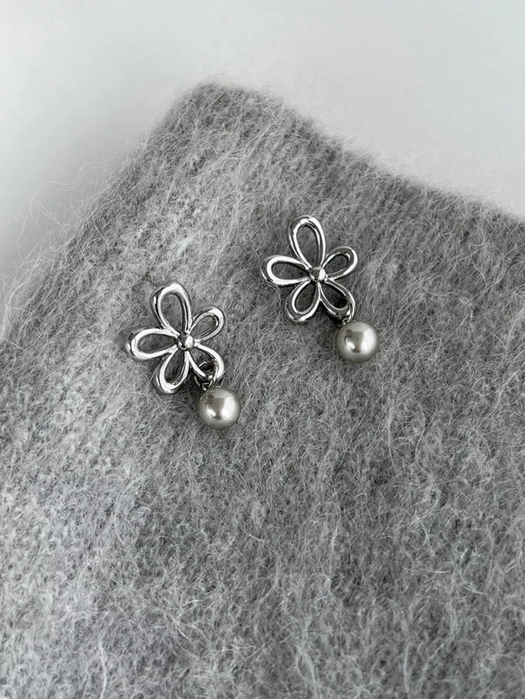 Flower-shaped drop earrings with pearl-like beads — detail view