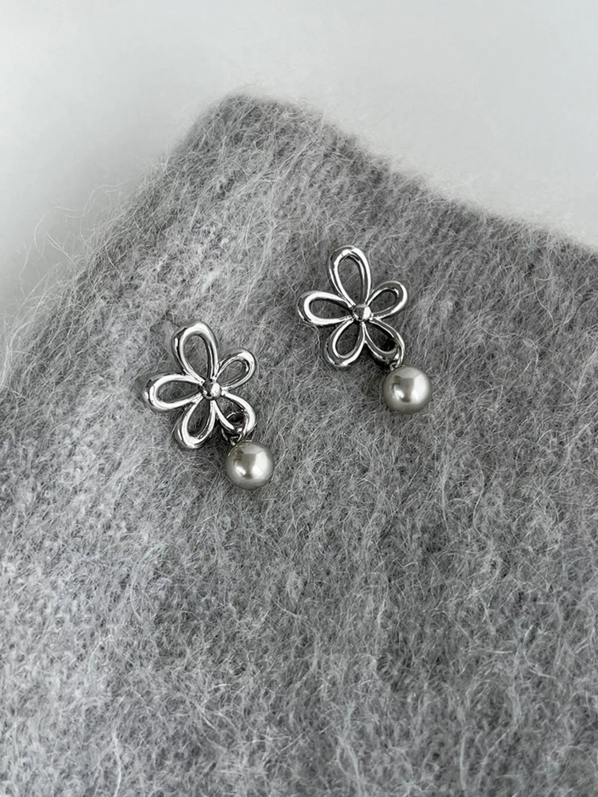 Flower-shaped drop earrings with pearl-like beads — detail view