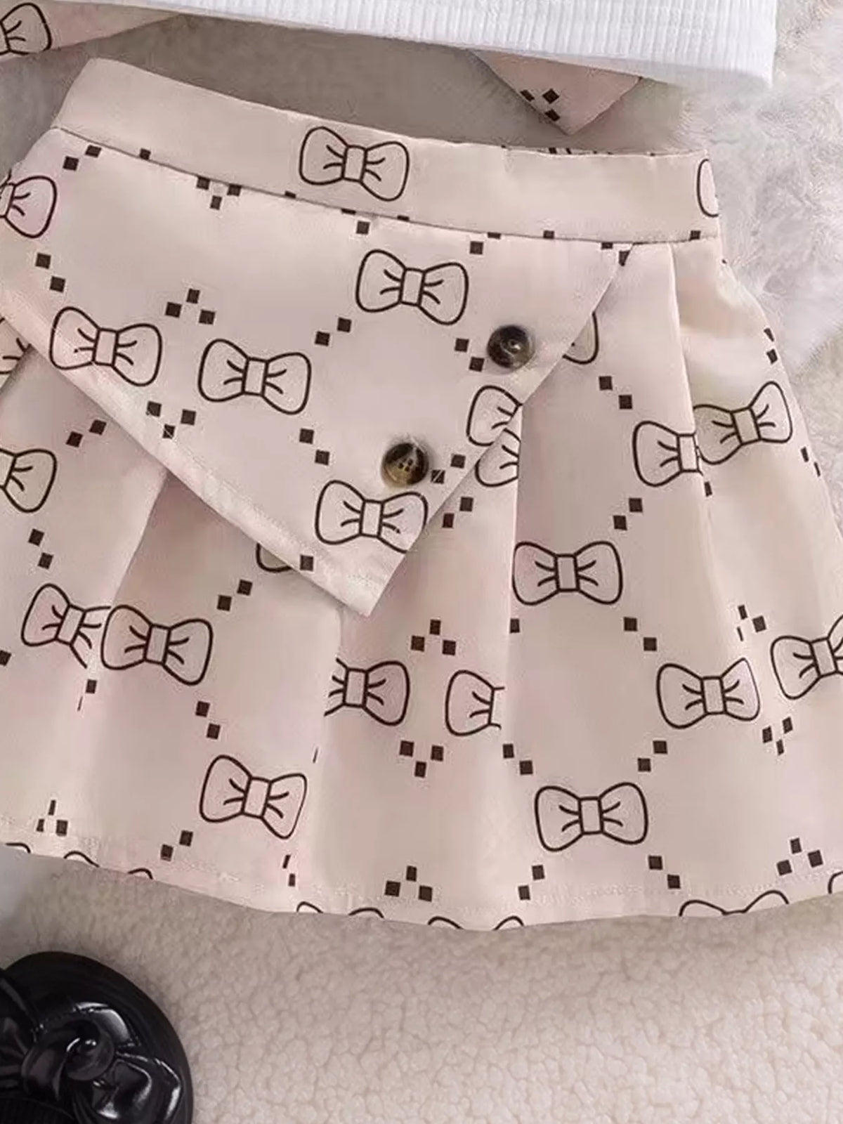 Bow pattern and pleats on the children’s skirt