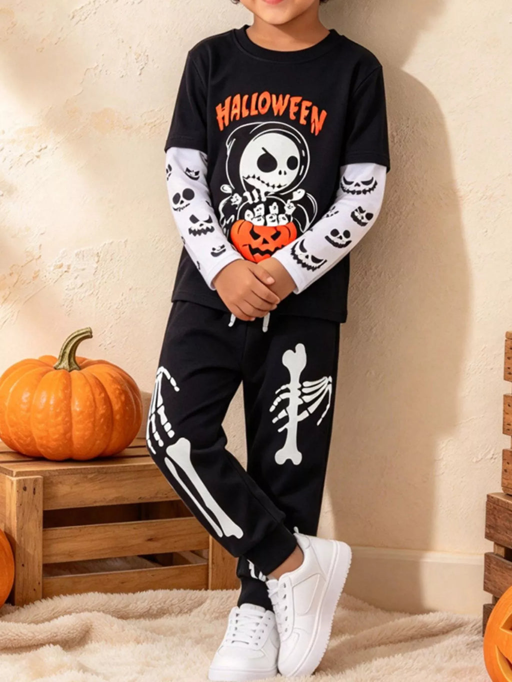 Children’s black Halloween skeleton graphic top and skeleton-print pants worn by a child