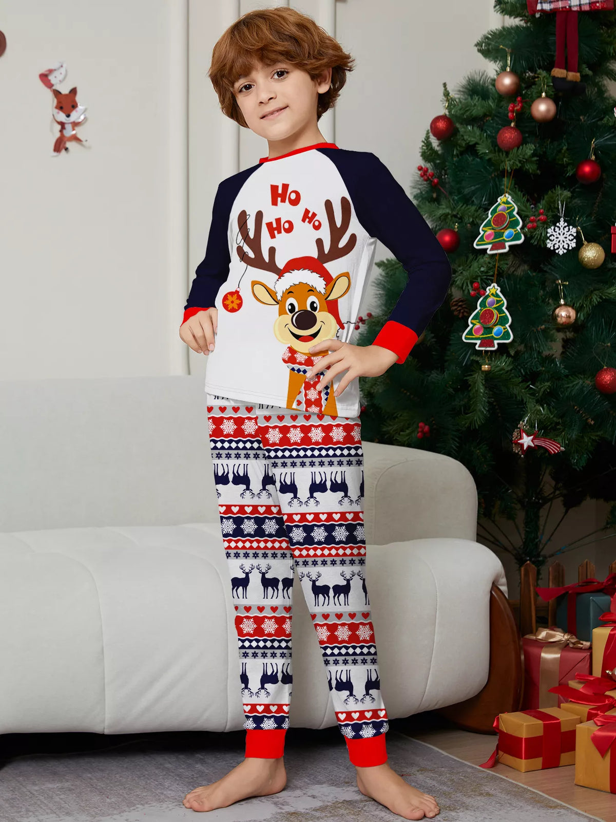 Child modeling the white and navy reindeer graphic Christmas pajamas.