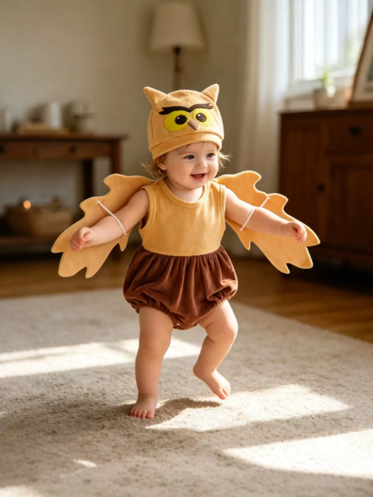 Children’s mustard owl-wing top, brown bottoms and owl hat worn by a child