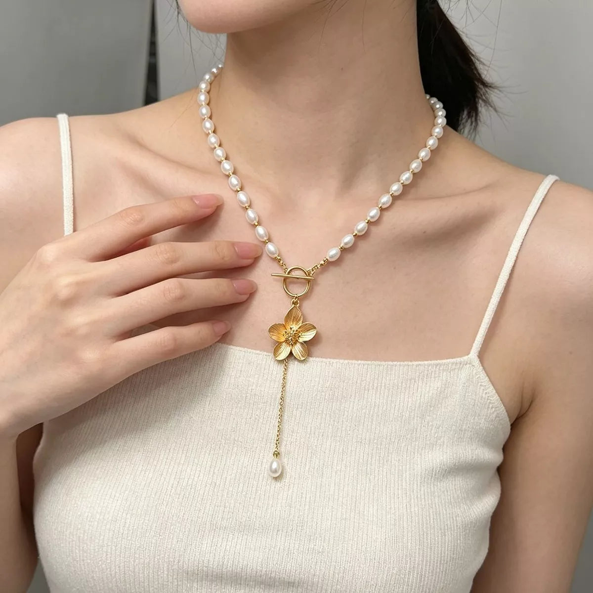 Pearl-like bead choker with gold-tone flower clasp and long pendant