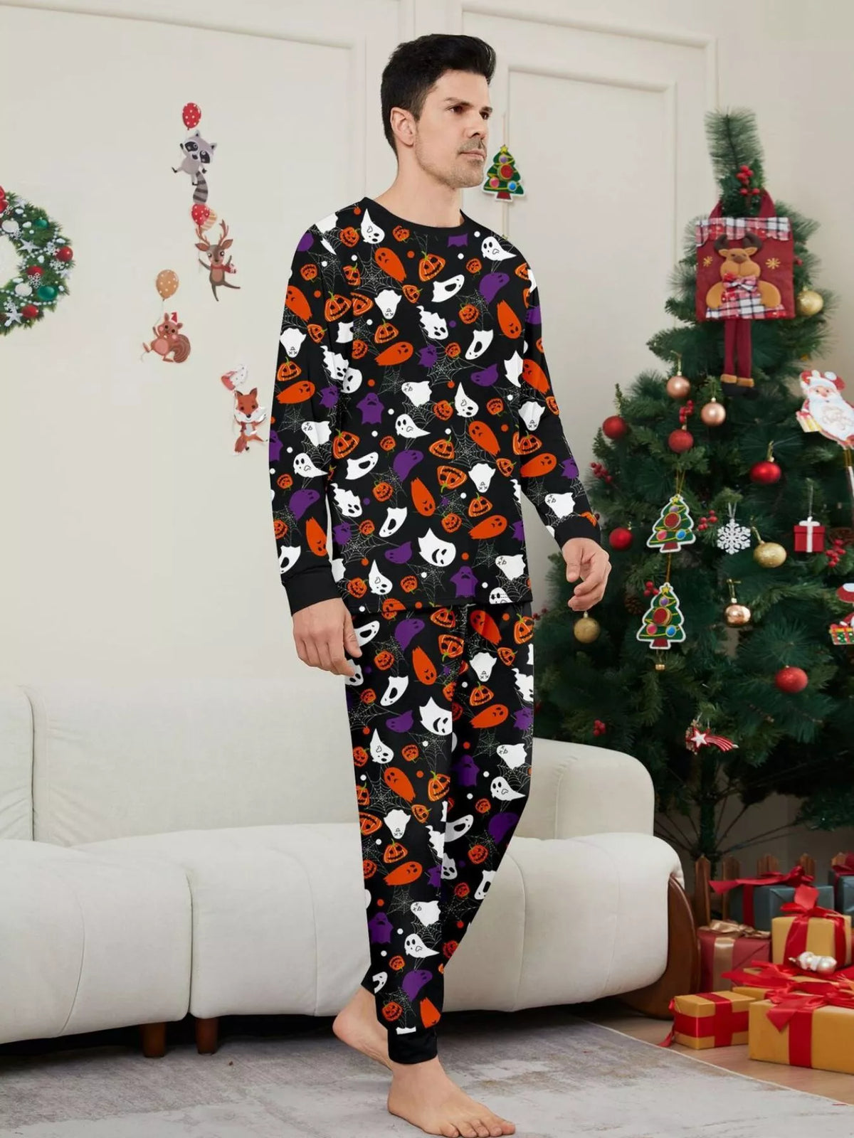 Black matching family pajamas with colorful Halloween ghost and pumpkin print worn by an adult