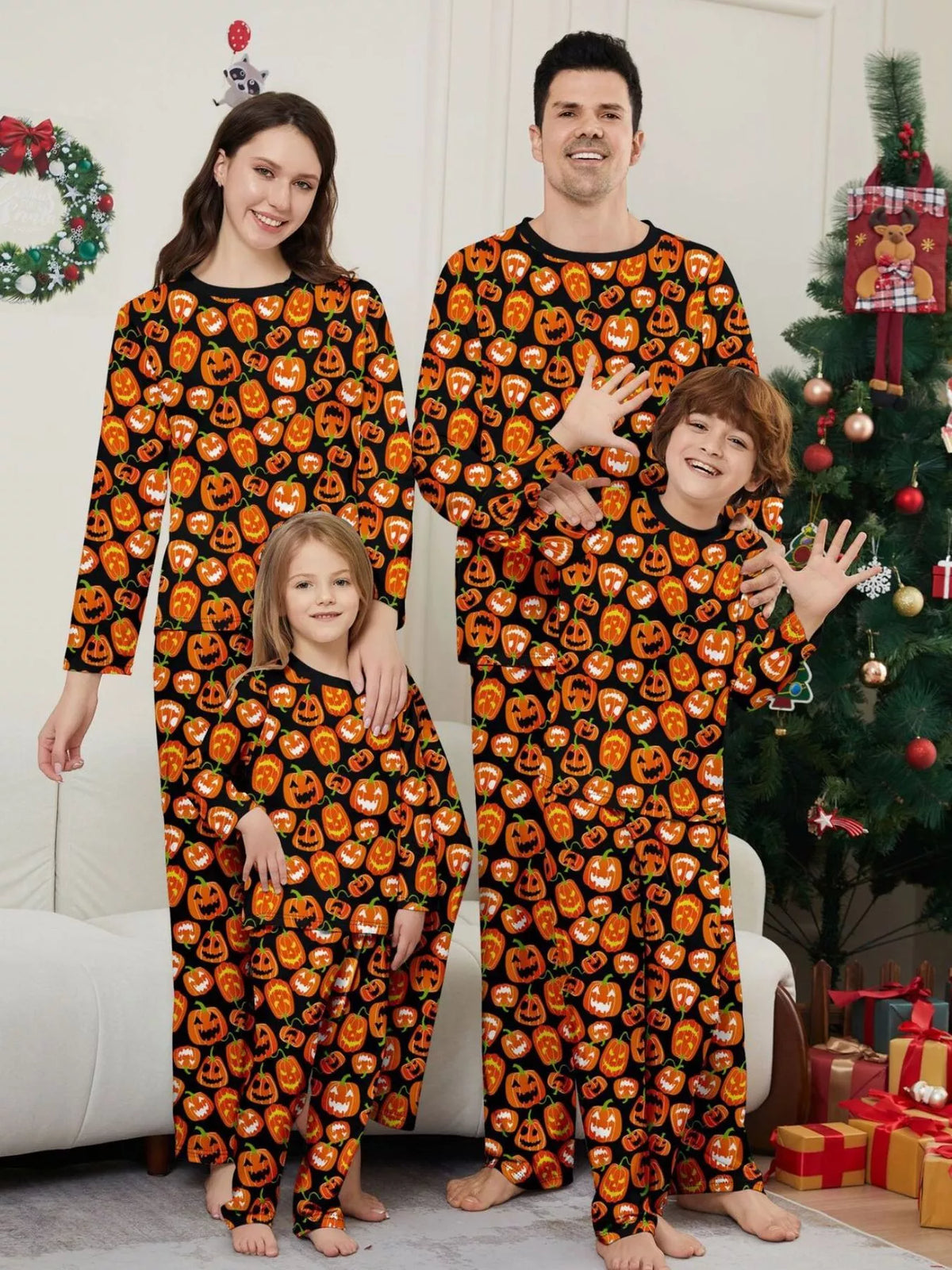 Family wearing matching black pajamas covered with orange jack-o'-lantern prints.
