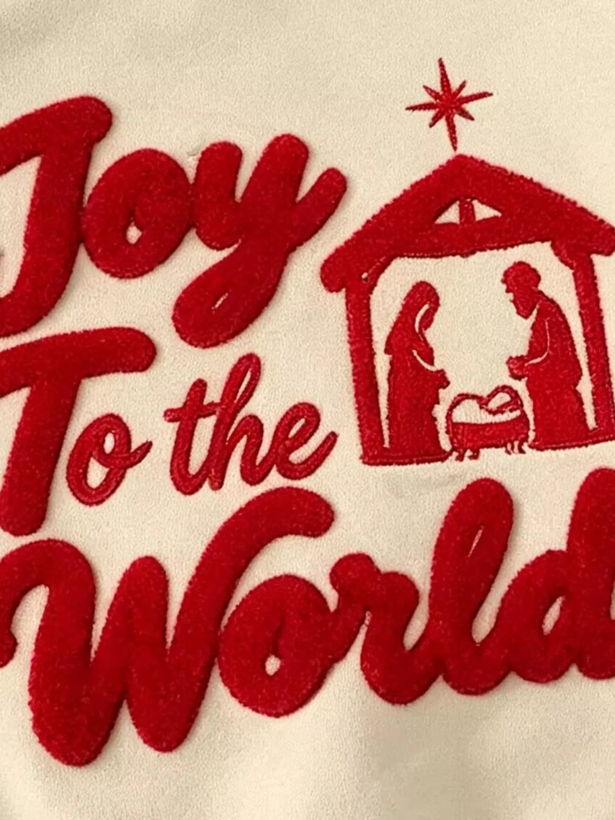 Close-up of the red Joy to the World lettering and nativity design.