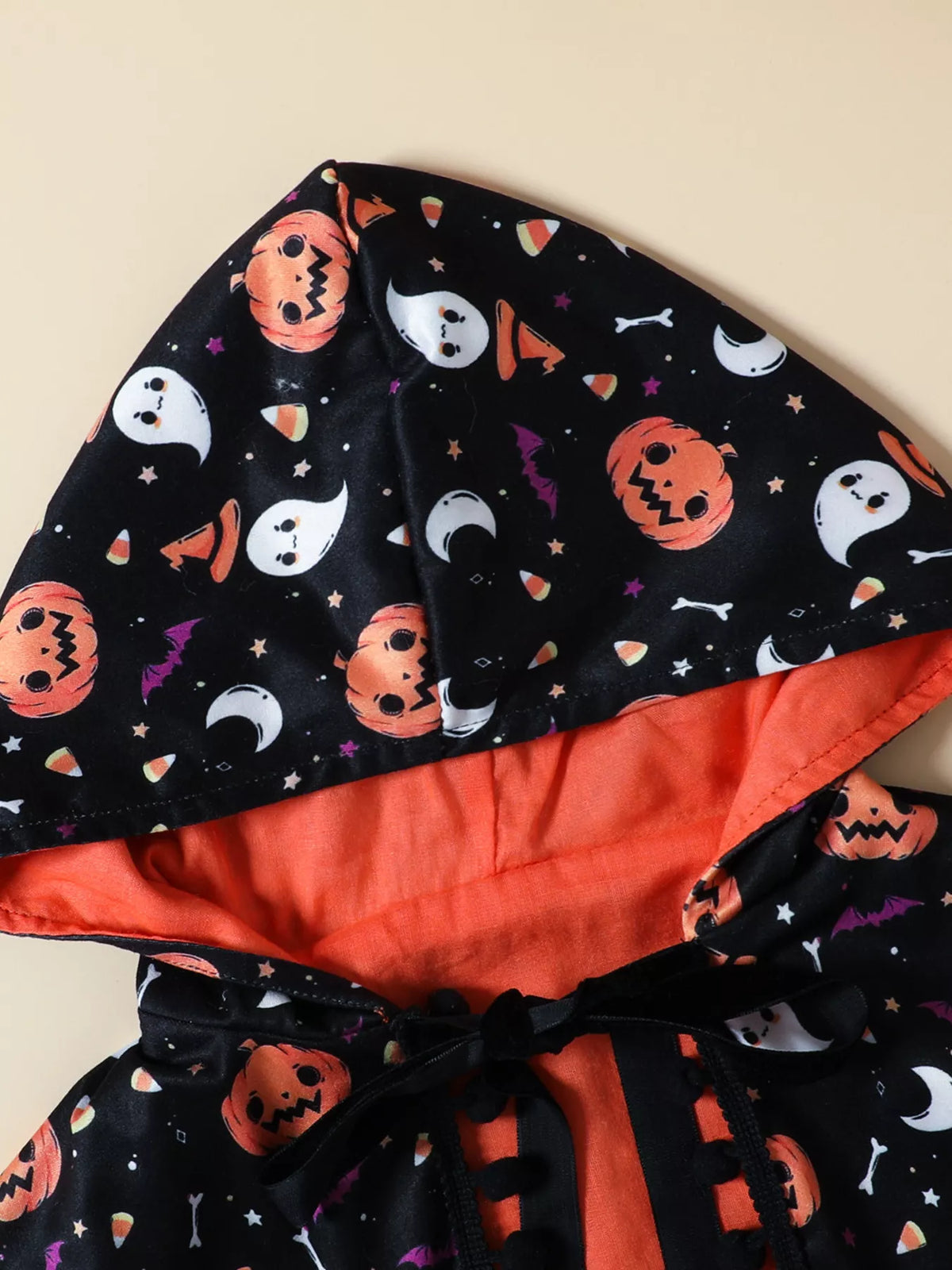 Ghost and pumpkin print with orange lining on the costume cape hood