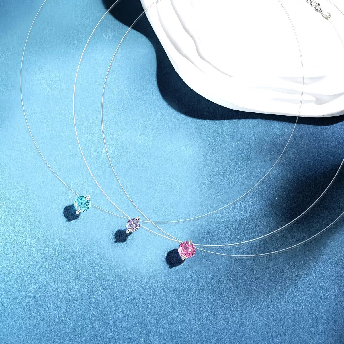 Silver-tone necklace with a round colored stone pendant — detail view