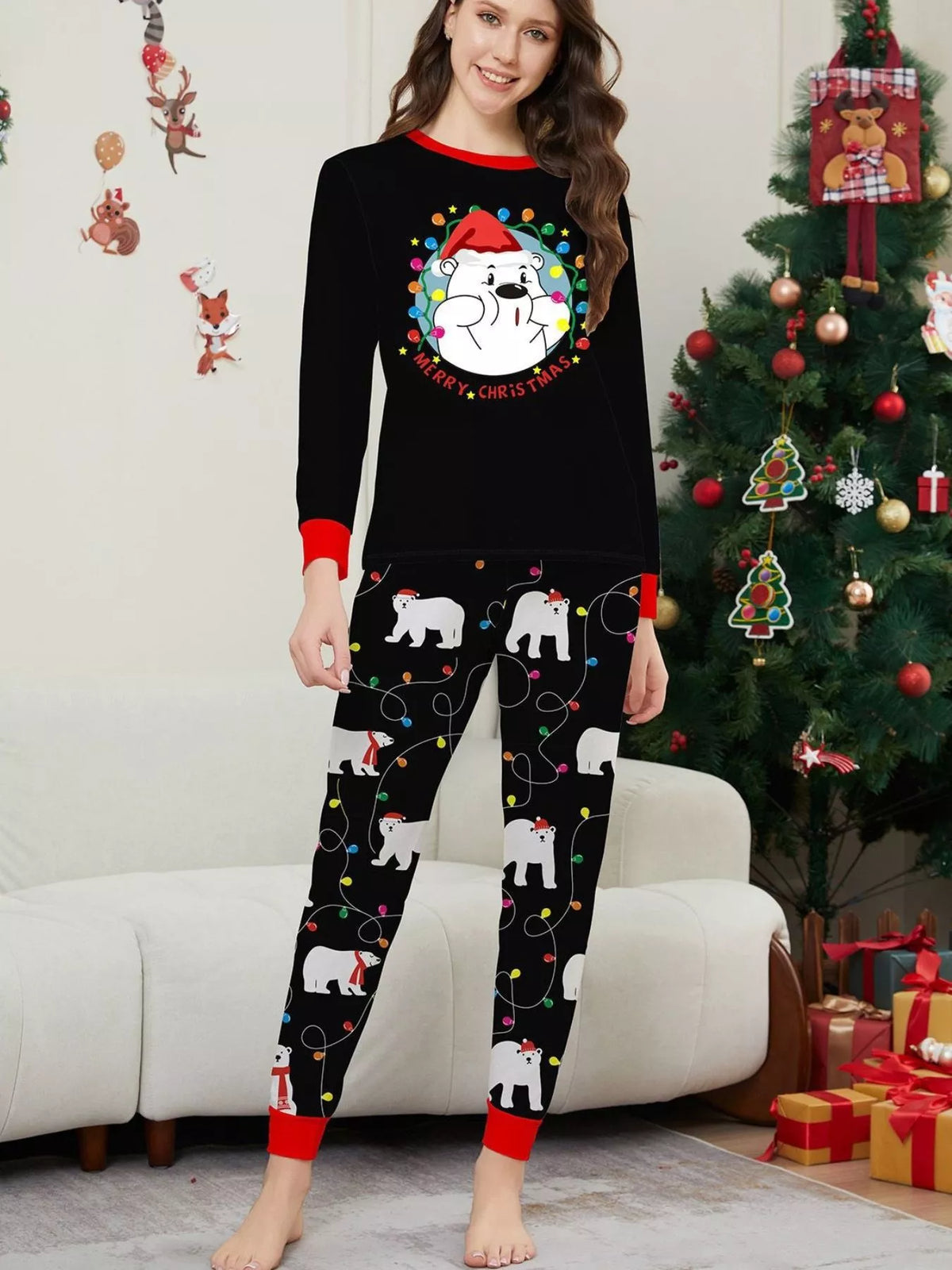 Woman modeling a black Christmas graphic top and black polar-bear-print pajama pants.