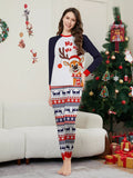 Woman modeling a white reindeer Christmas graphic top with navy sleeves and festive striped pants.