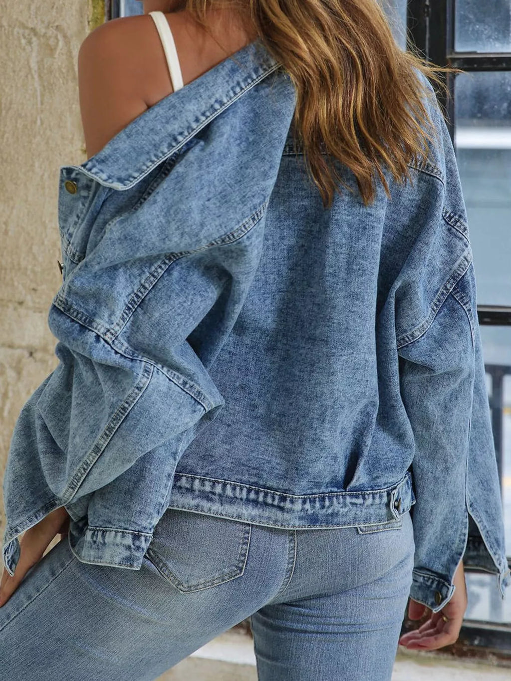 Angled back view of the light-blue jacket's dropped shoulder and hem.