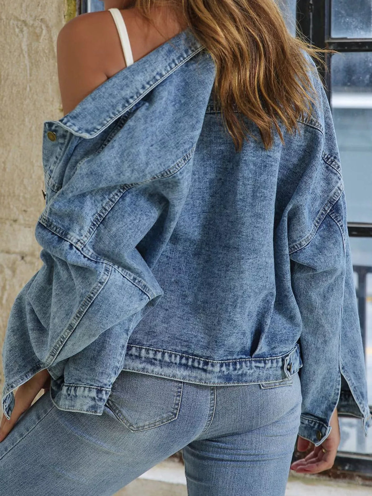 Angled back view of the light-blue jacket's dropped shoulder and hem.
