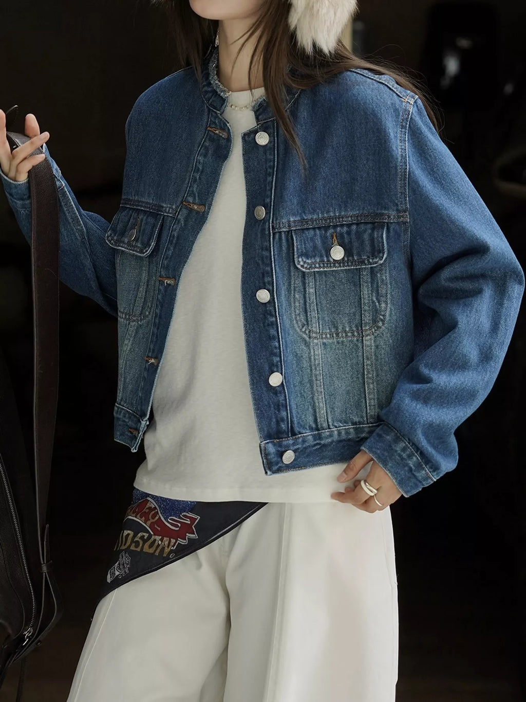 Blue cropped denim jacket modeled with one hand at the hip.