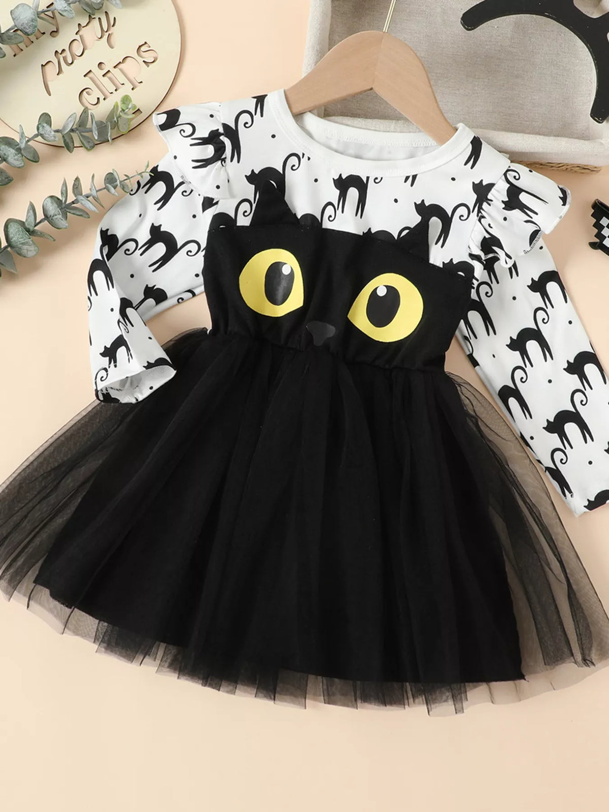Front view of the white cat-print dress with black cat face and black tulle skirt.