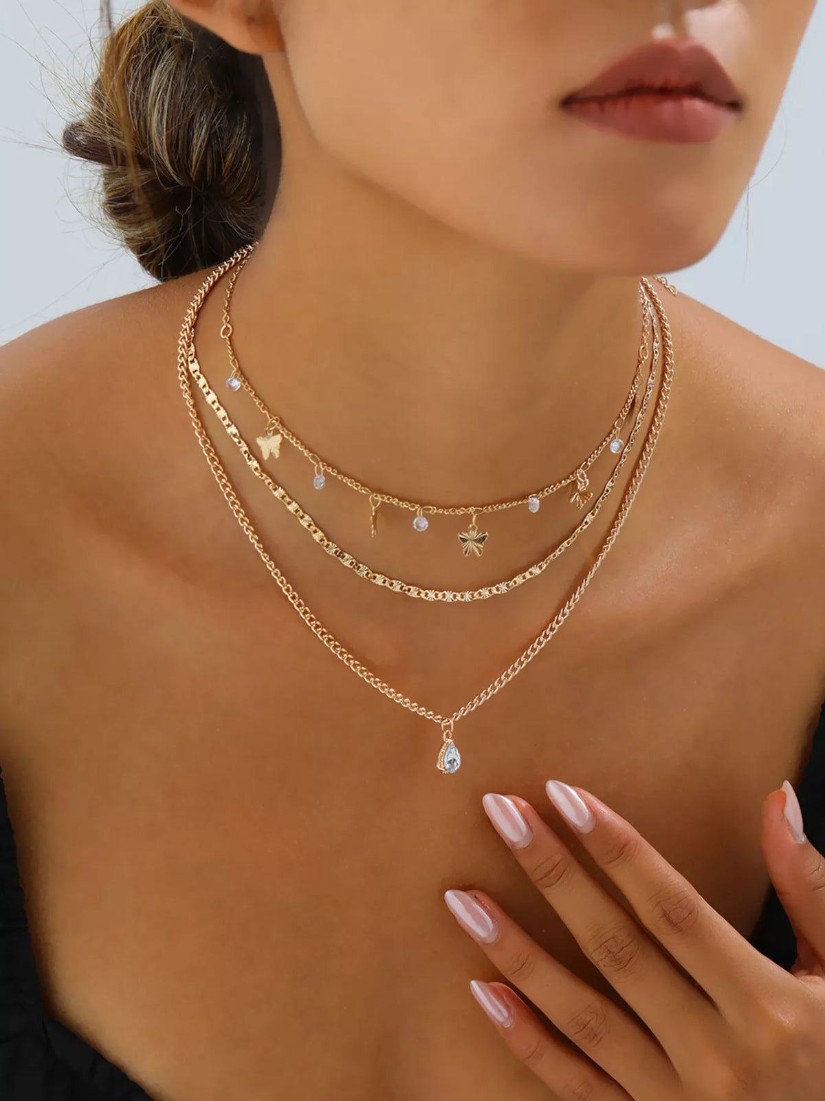 Layered gold-tone necklace with butterfly and clear stone charms