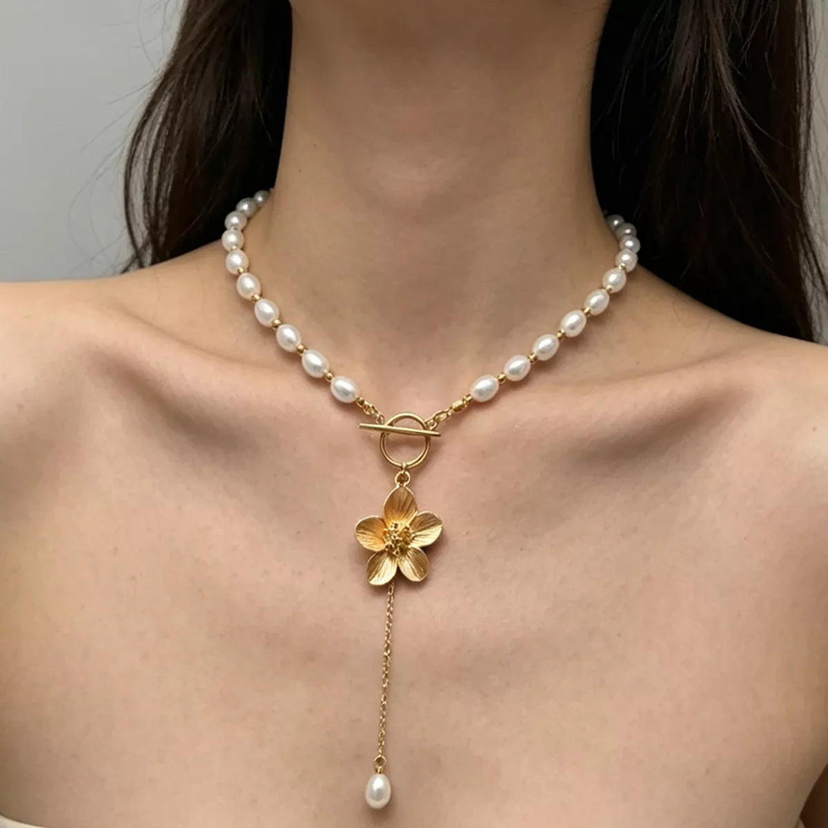 Pearl-like bead choker with gold-tone flower clasp and long pendant
