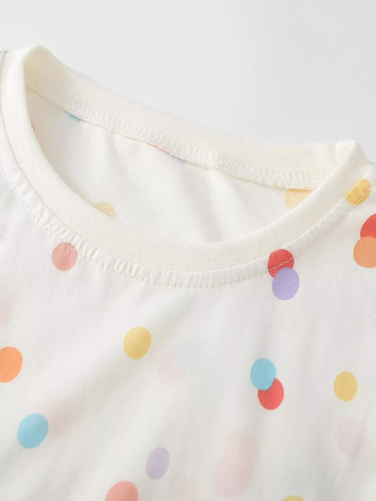 Round neckline and multicolor dots on the white long-sleeve top
