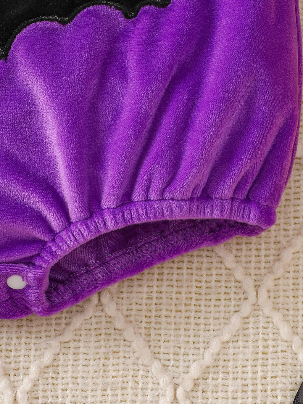 Gathered purple leg opening on the baby bodysuit