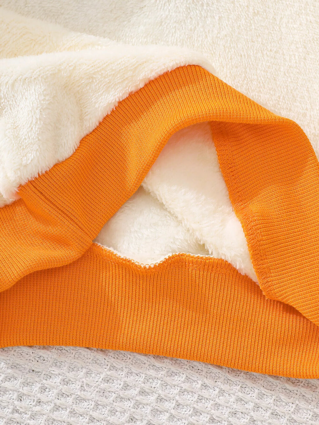 Orange cuff and cream sleeve detail of the ghost graphic top