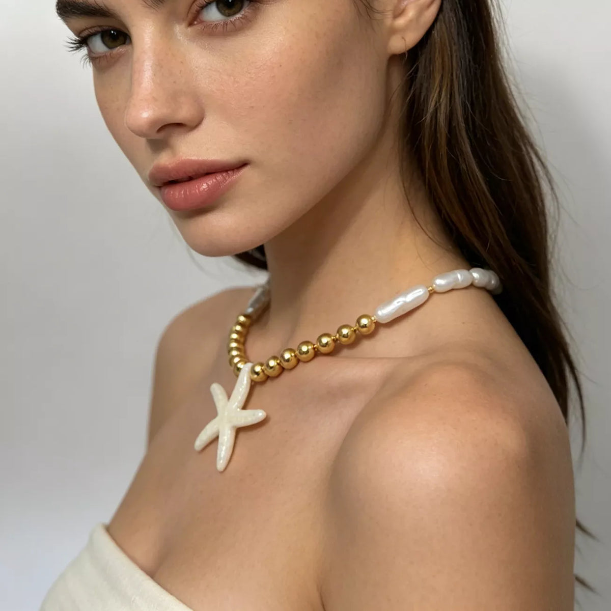 Starfish pendant necklace with gold-tone beads and white shell-like links