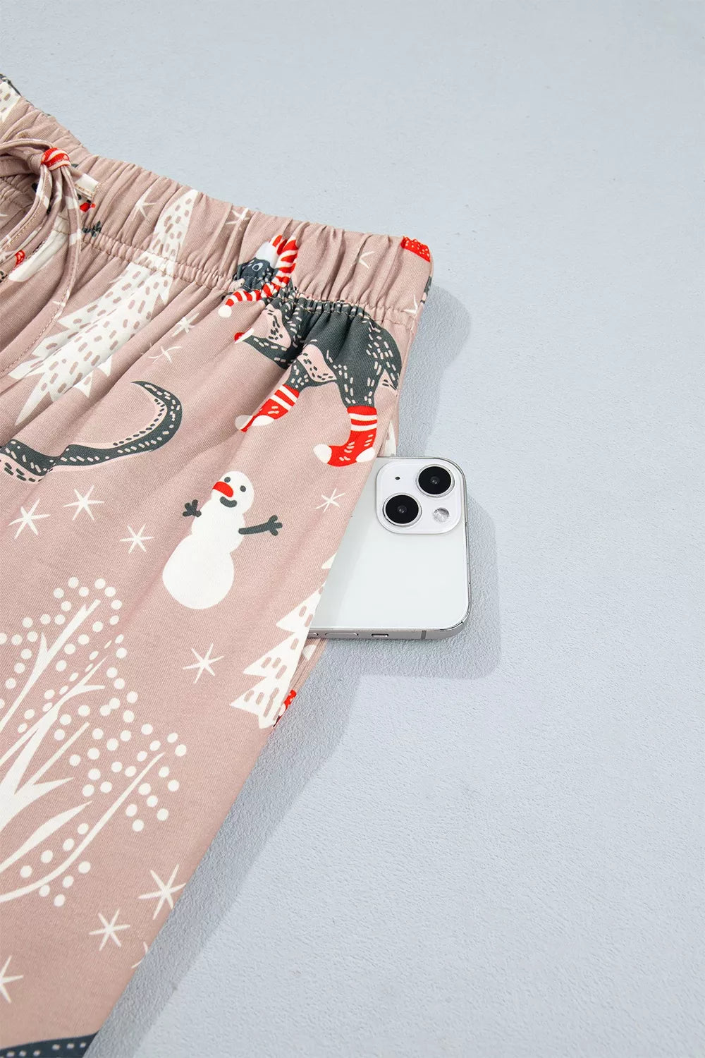 Pink long-sleeve pajama shirt and pants with dinosaur Christmas print — detail view