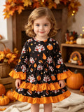 Children’s black turkey-print long-sleeve dress with orange ruffle trim worn by a child