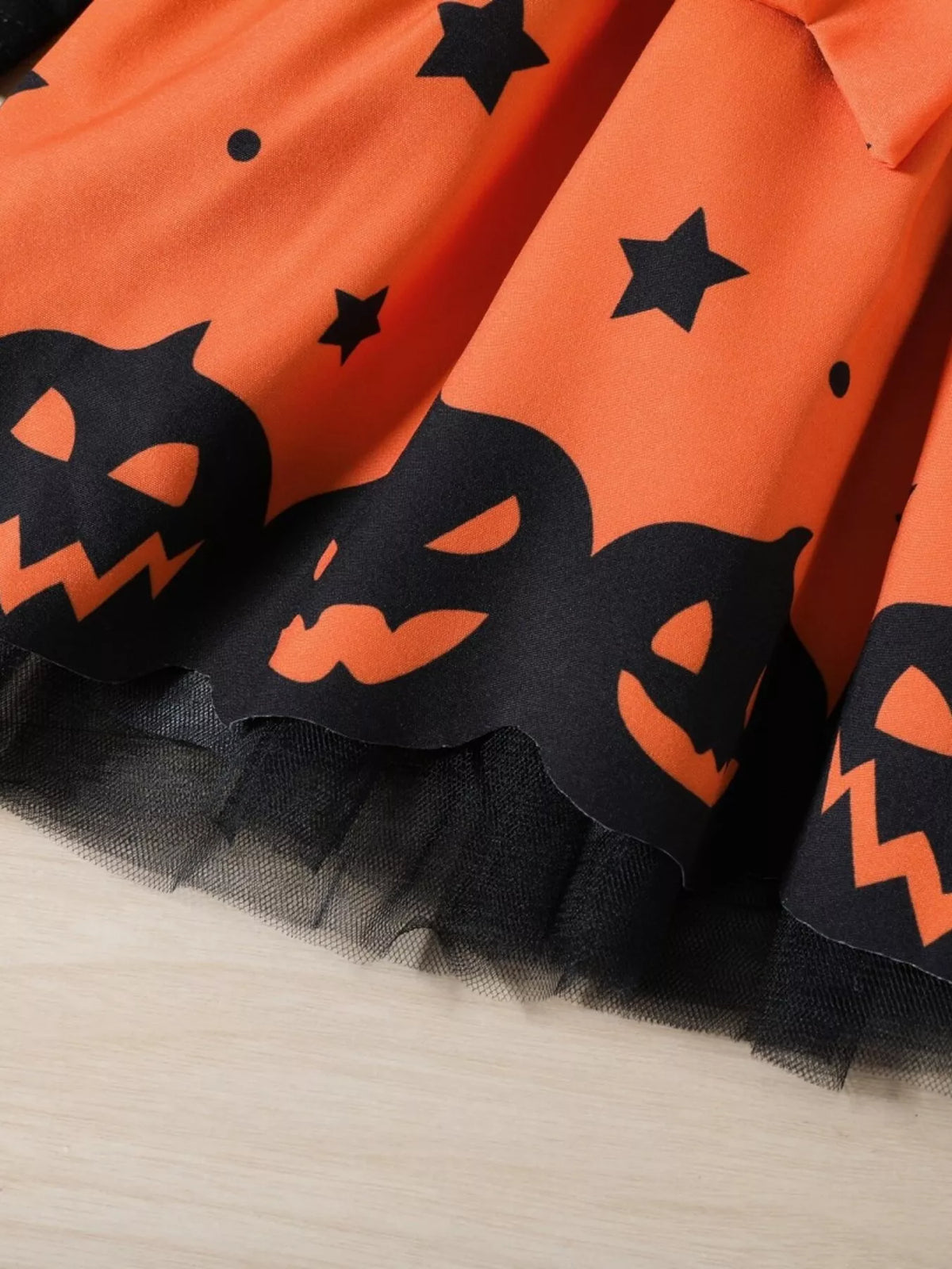 Black pumpkin-face border and tulle hem on the orange dress skirt