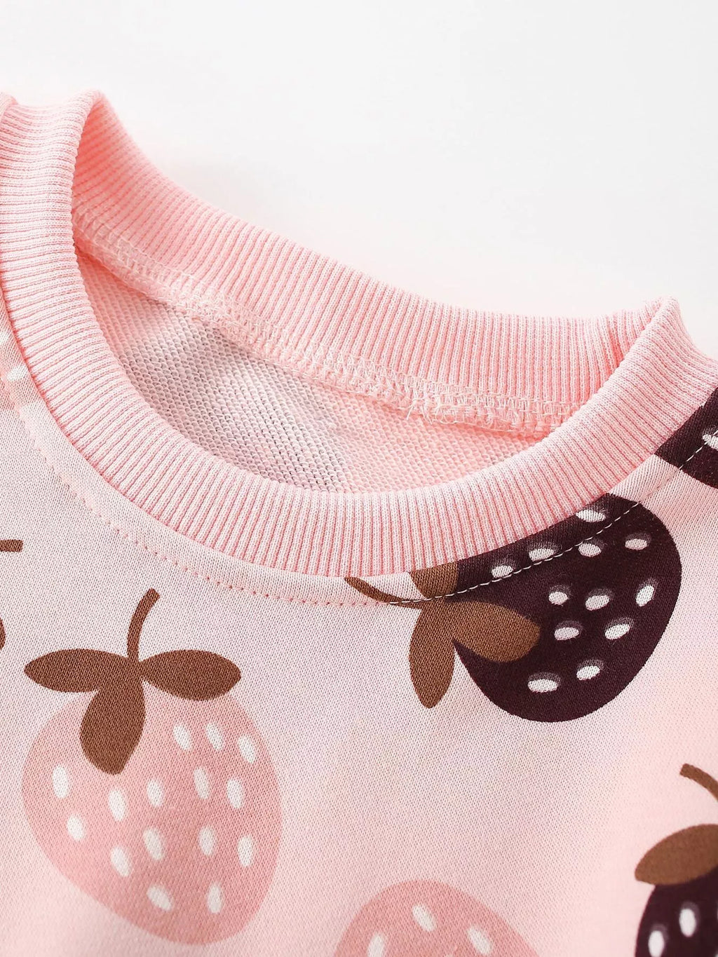 Close-up of the pink strawberry sweatshirt's ribbed crew neckline.