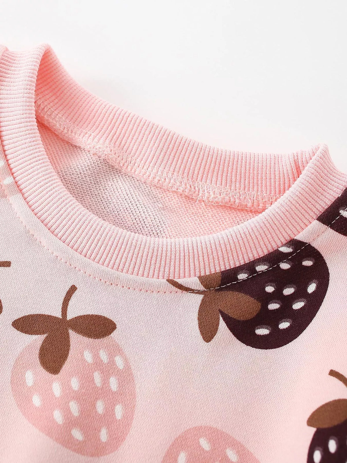 Close-up of the pink strawberry sweatshirt's ribbed crew neckline.