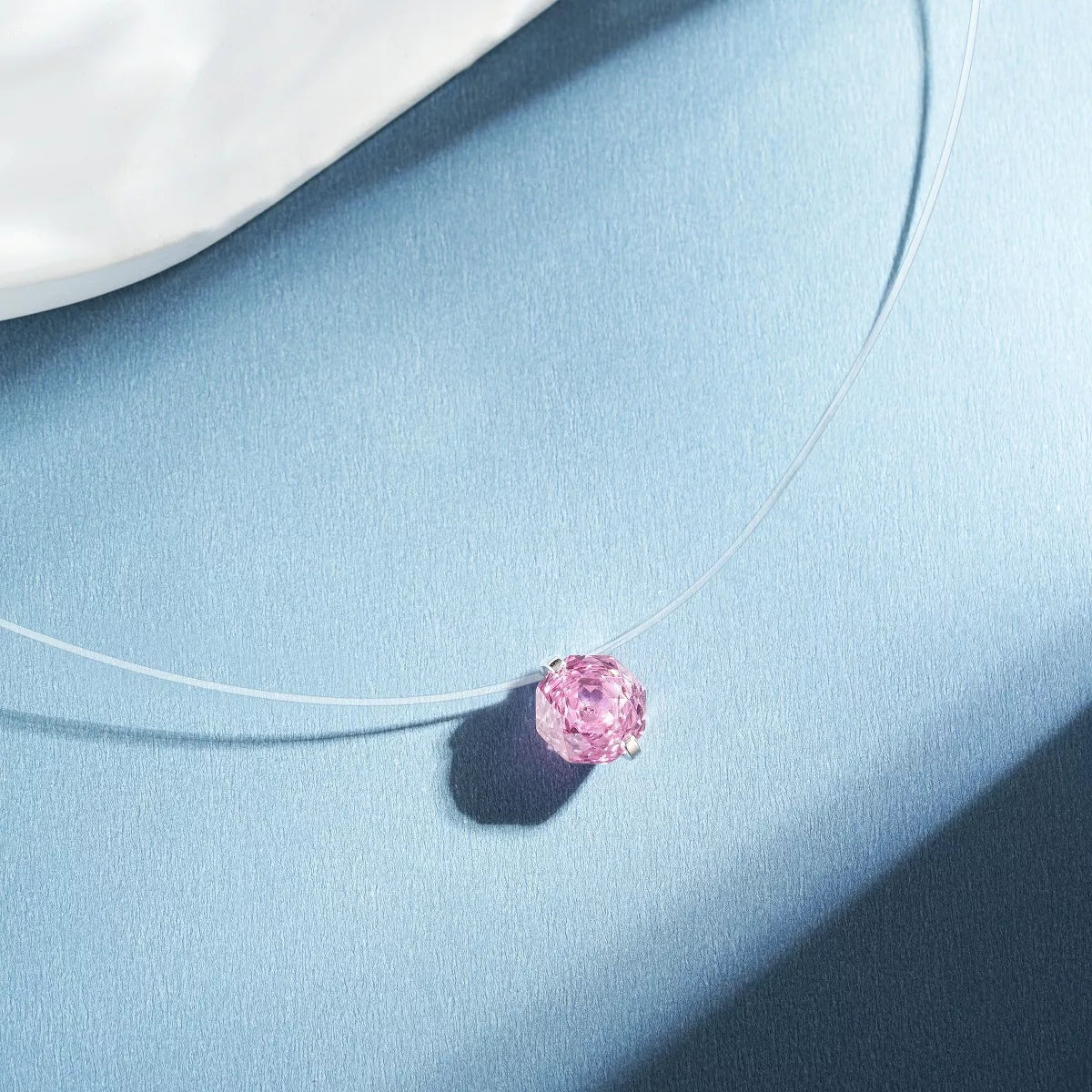 Silver-tone necklace with a round colored stone pendant — detail view