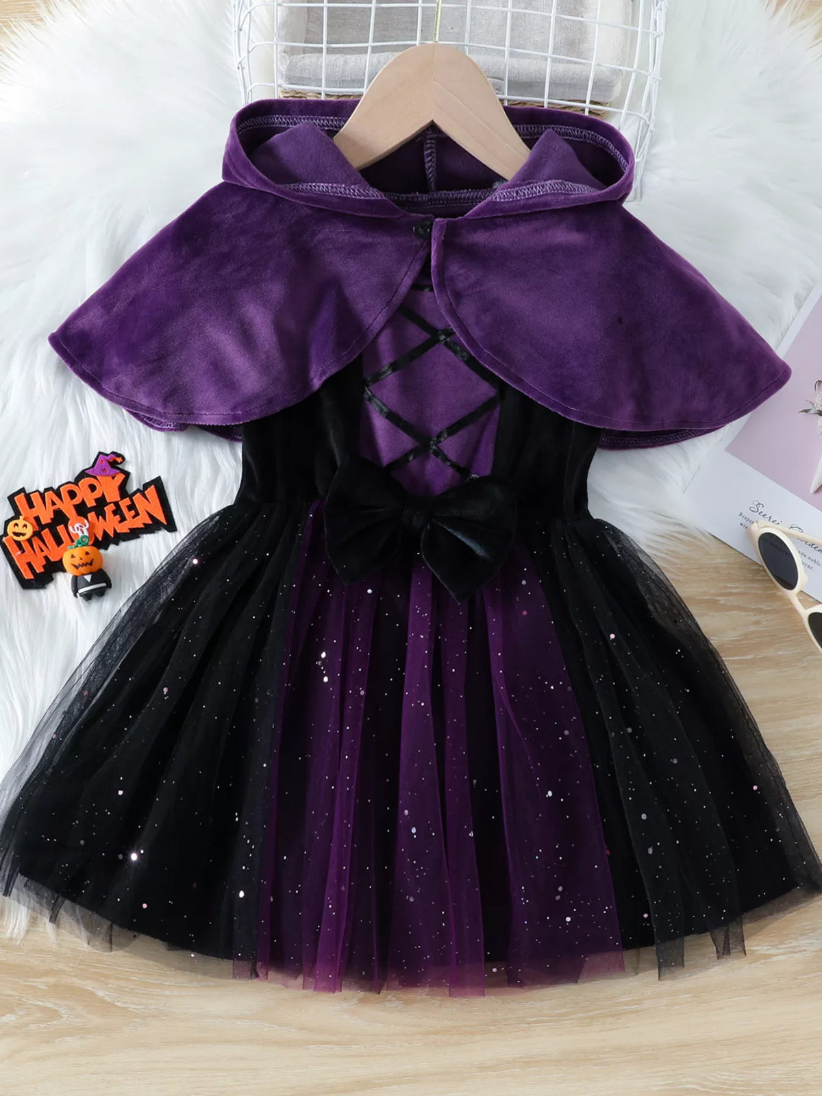 Front view of the purple hooded cape over the black-and-purple Halloween dress.