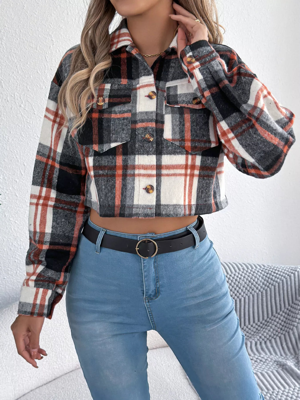 Front detail of the black plaid jacket's collar and buttoned pockets.