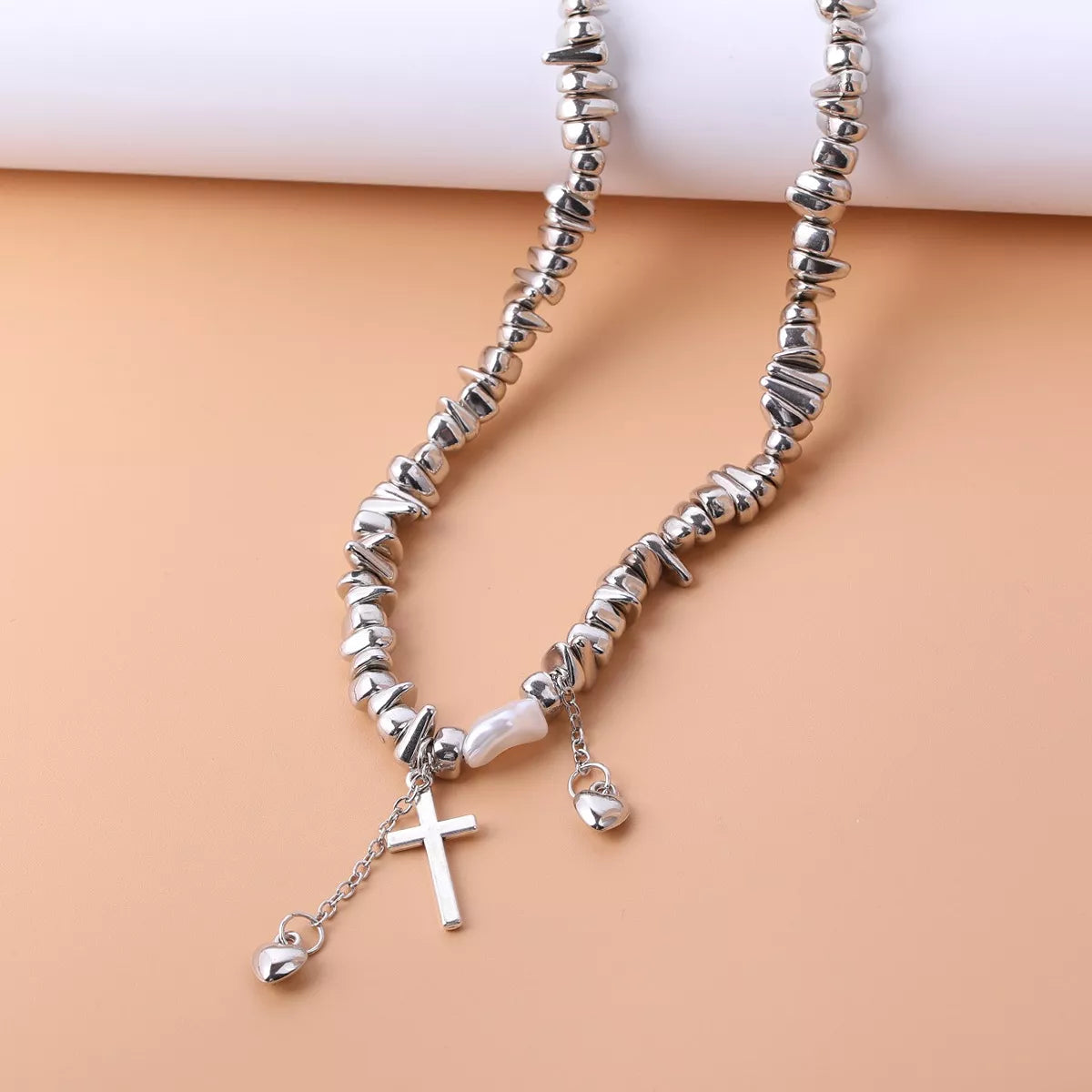 Chunky silver-tone chain necklace with cross and dangling charms — detail view