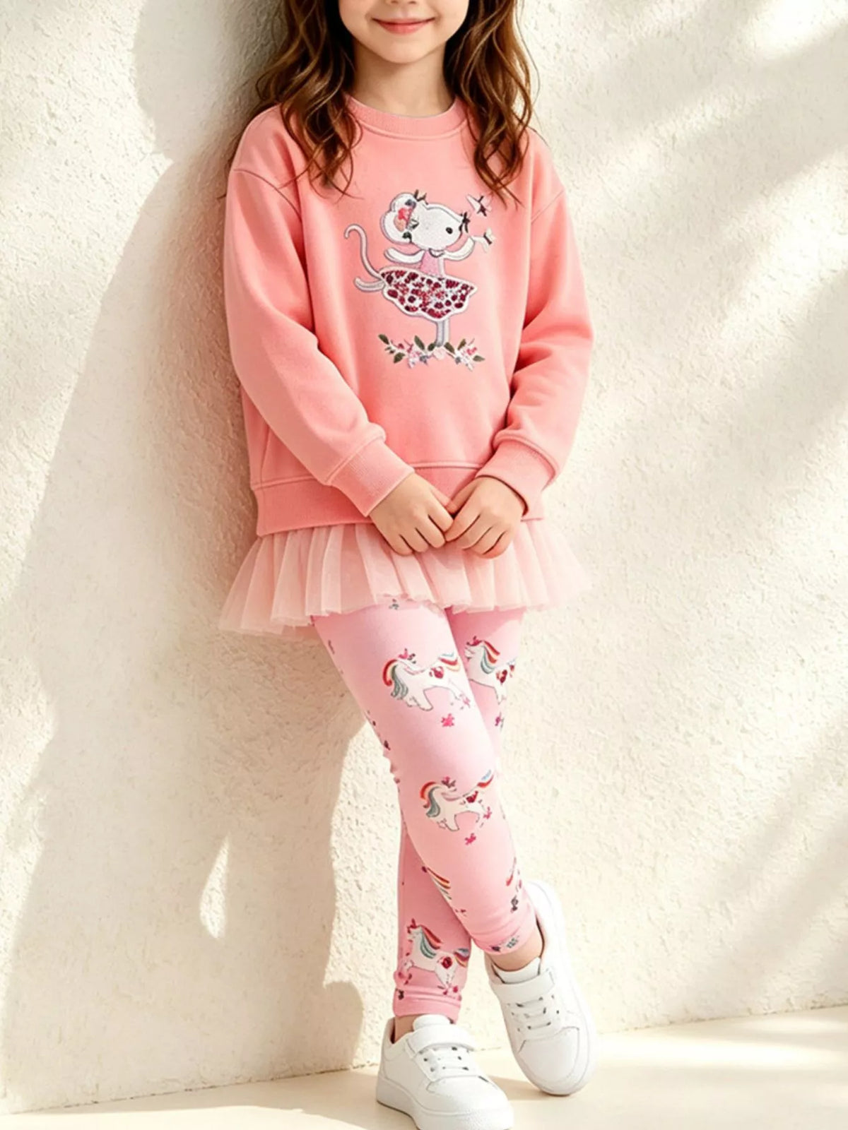 Coral embroidered sweatshirt with ruffle hem and pink printed leggings worn by a child