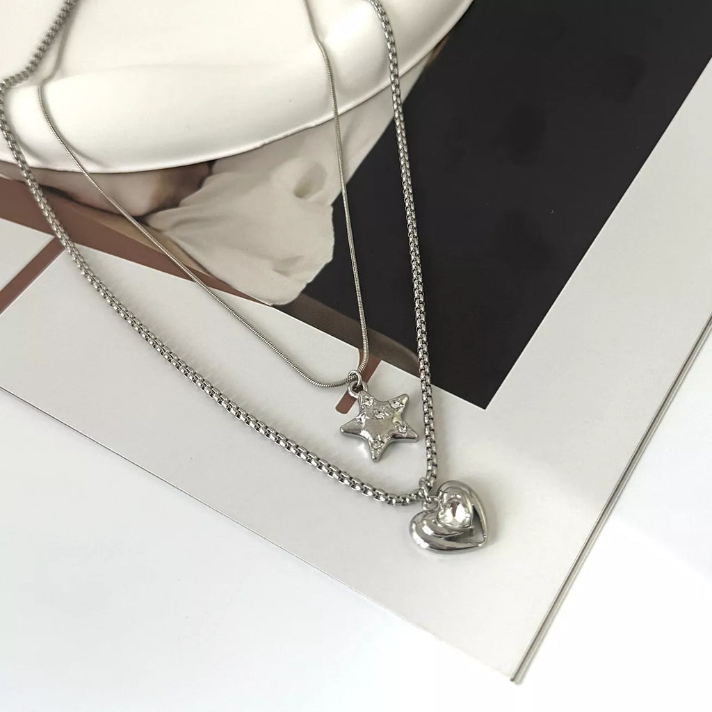 Layered silver-tone star and heart pendant necklaces — detail view