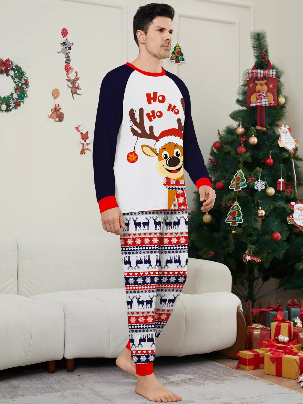 Man modeling a white reindeer Christmas graphic top with navy sleeves and festive striped pajama pants.