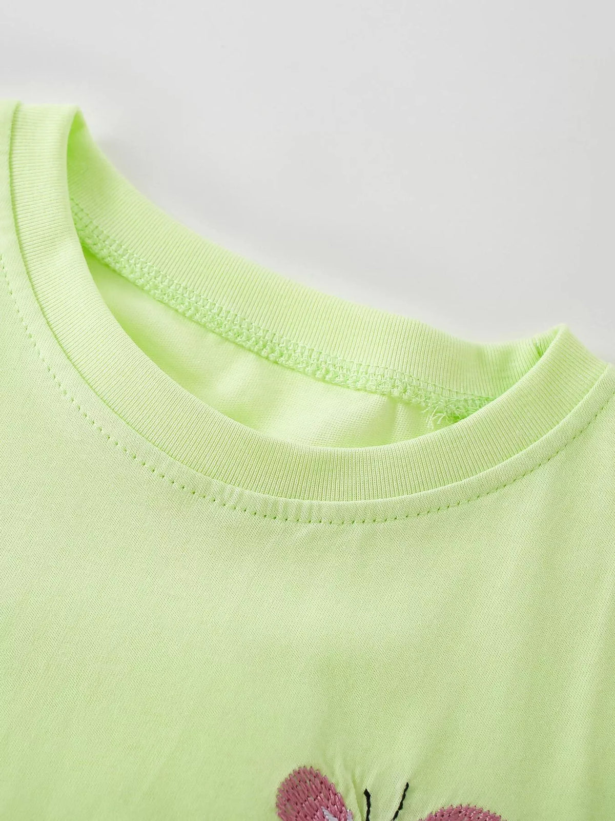 Close-up of the light green top's rounded neckline.