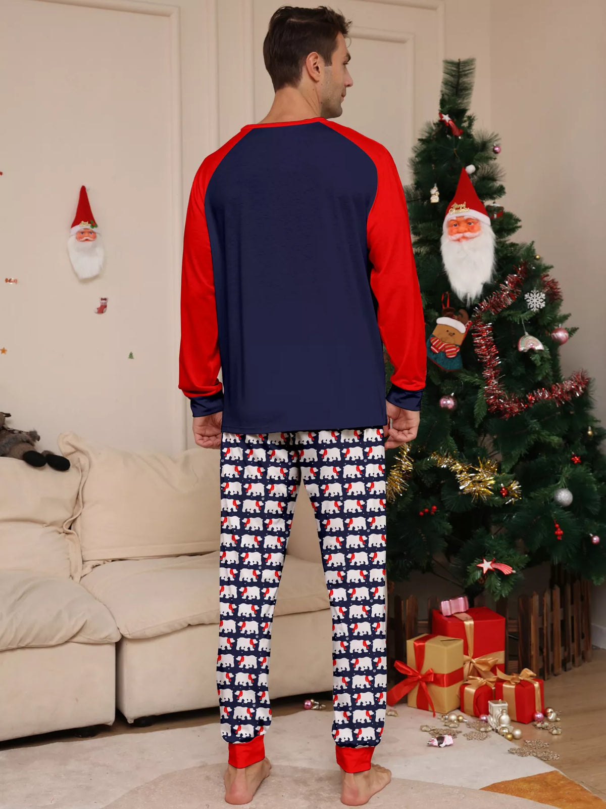 Navy and red Christmas graphic pajama top with matching festive-print pants worn by an adult — back view
