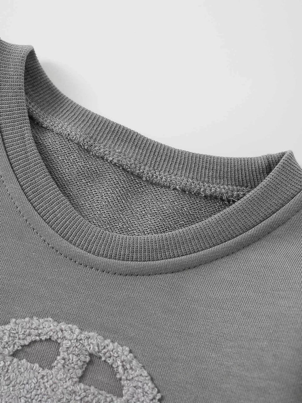 Close-up of the gray car sweatshirt's ribbed crew neckline.