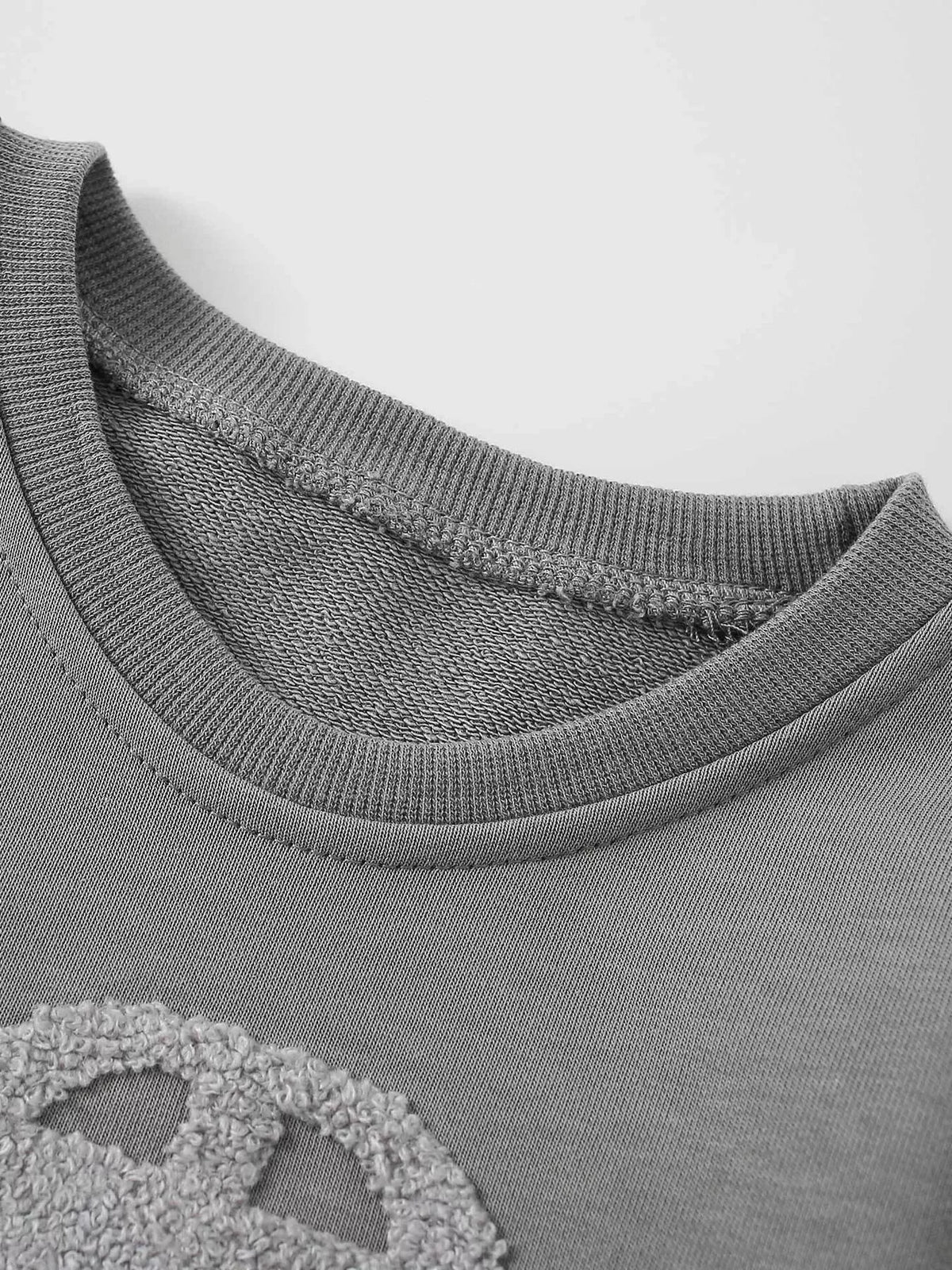Close-up of the gray car sweatshirt's ribbed crew neckline.