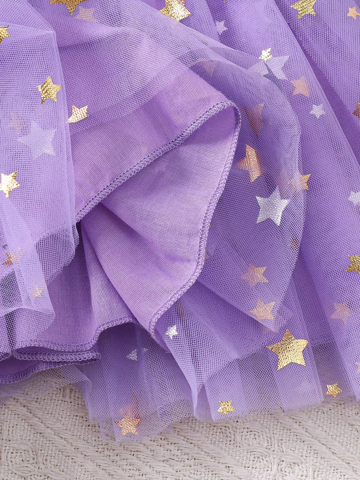 Purple mesh fabric with scattered gold stars