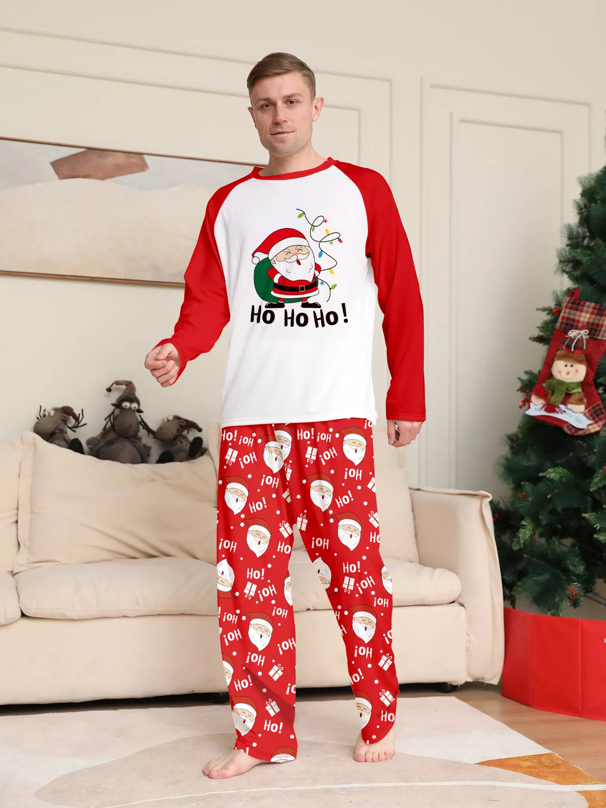 Man modeling a white Santa graphic top with red sleeves and red printed pants.