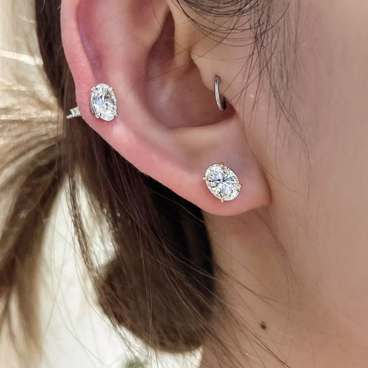 Silver-tone stud earrings with clear faceted stones — detail view
