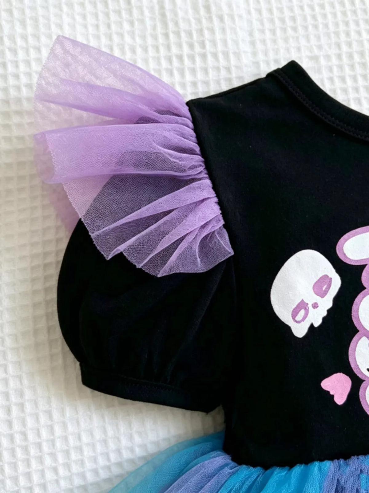 Close-up of a purple tulle sleeve on the black skeleton dress.