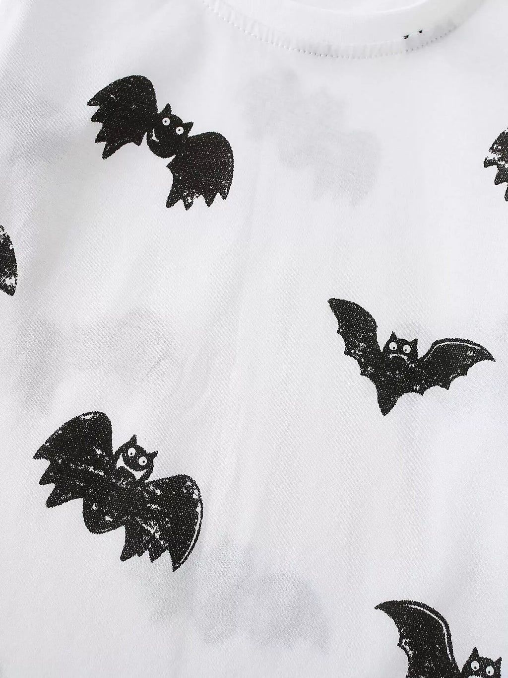 Close-up of the black bat illustrations on the white top.