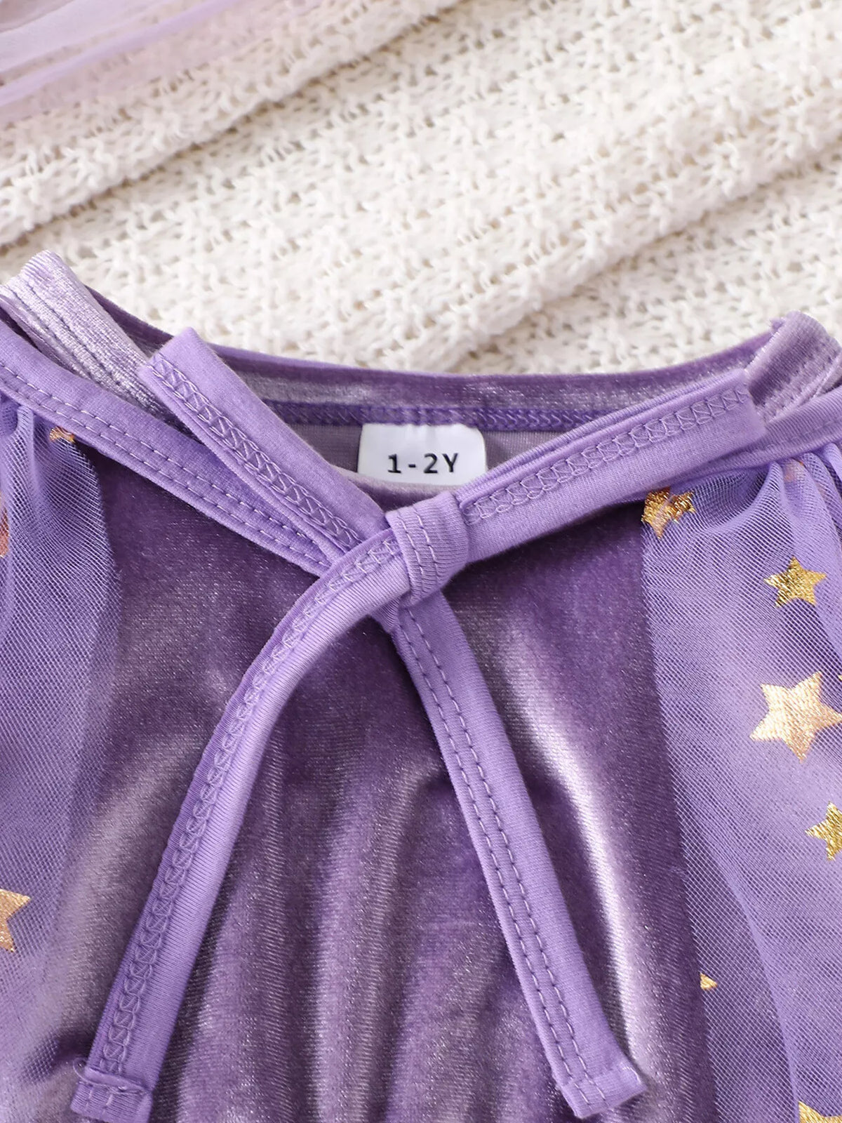 Purple neckline ties and soft collar detail on the costume dress