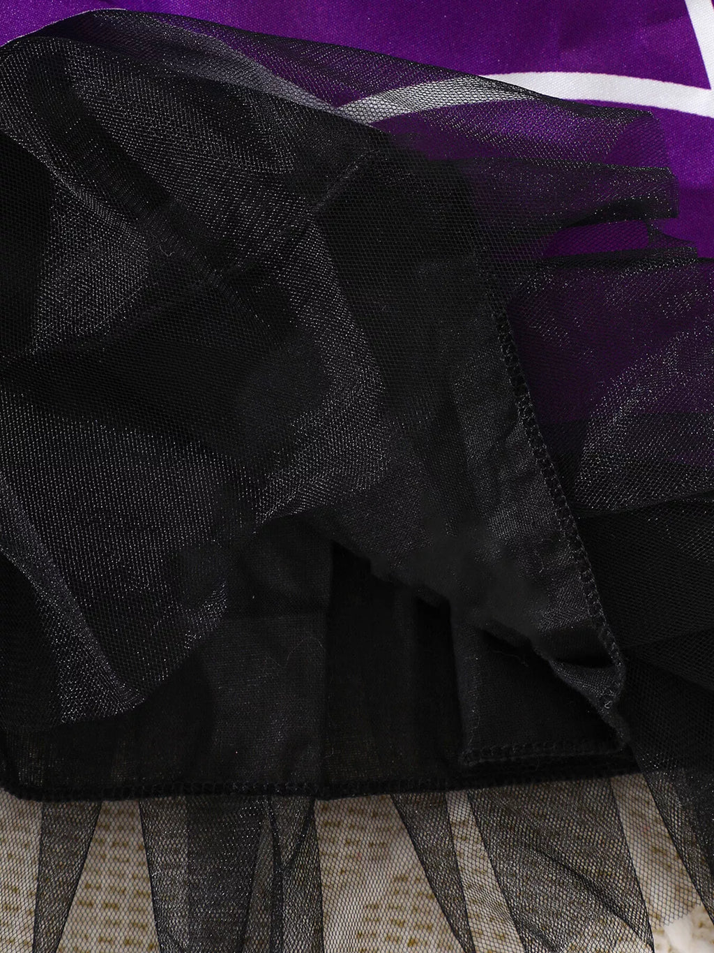Close-up of the black tulle hem under the purple spiderweb skirt.